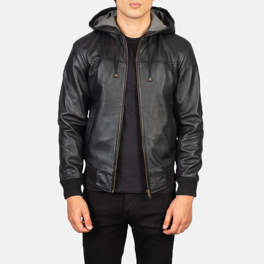 Front view of a man modeling an open black leather bomber jacket, showing the ribbed collar, cuffs, hem, and the iconic zippered arm pocket.