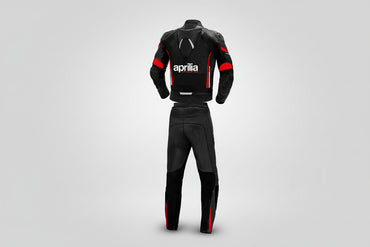 Detailed view of the Aprilia Racing chest branding, Akrapovič patch, and accordion stretch panels on a professional racing suit.