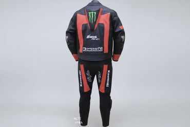 Detailed view of the Monster Energy claw logo, Kawasaki branding, and red technical leather panels on a professional two-piece suit.