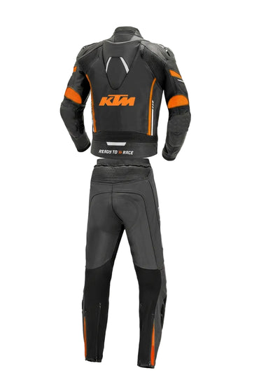 Detailed view of the KTM chest logo, orange aerodynamic strikes, and external knee sliders on a professional racing suit.