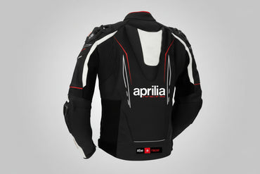 Detailed view of the Aprilia Racing chest branding, Akrapovič logo, and accordion stretch panels on a professional racing jacket.