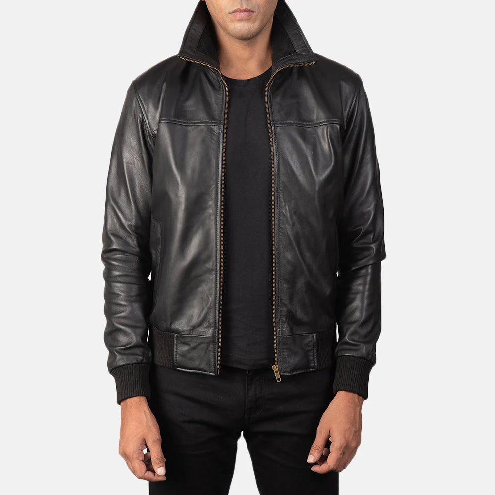 Front view of a man modeling an open black leather bomber jacket, showing the ribbed collar, cuffs, hem, and the iconic zippered arm pocket.