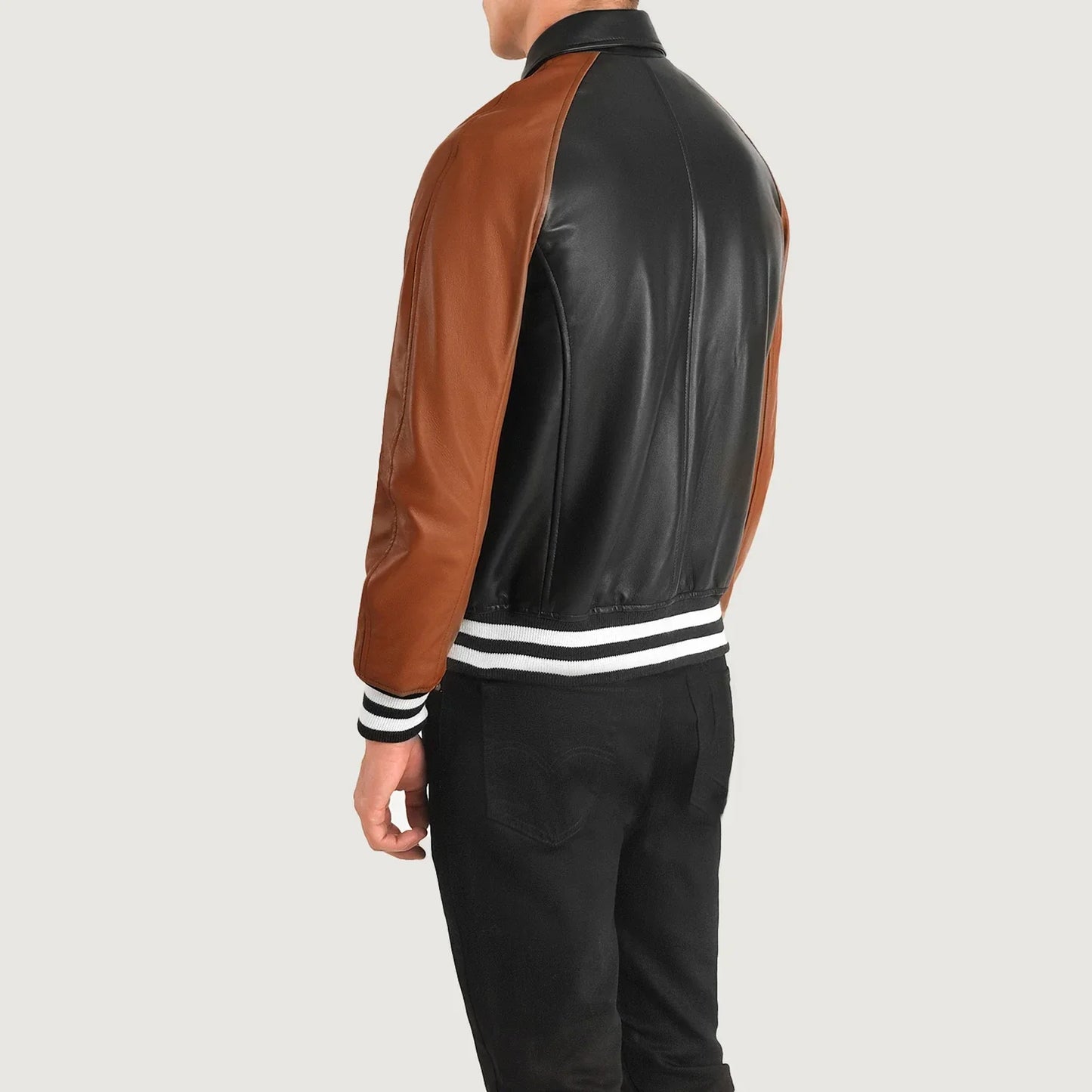 Black leather jacket with brown sleeves and a striped hem, designed in a modern, color-blocked bomber style.