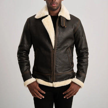 Back view of a man wearing a brown sheepskin leather jacket with thick white shearling visible at the collar, cuffs, and hem, highlighting the quality of the material.