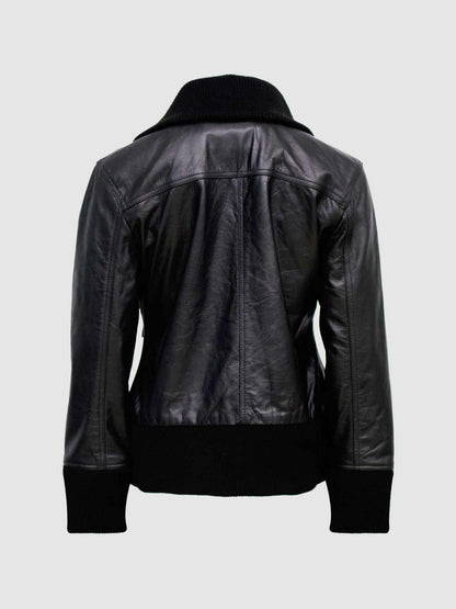 Black leather jacket featuring gold/brass snaps on flap pockets and a wide, ribbed knit stand collar.