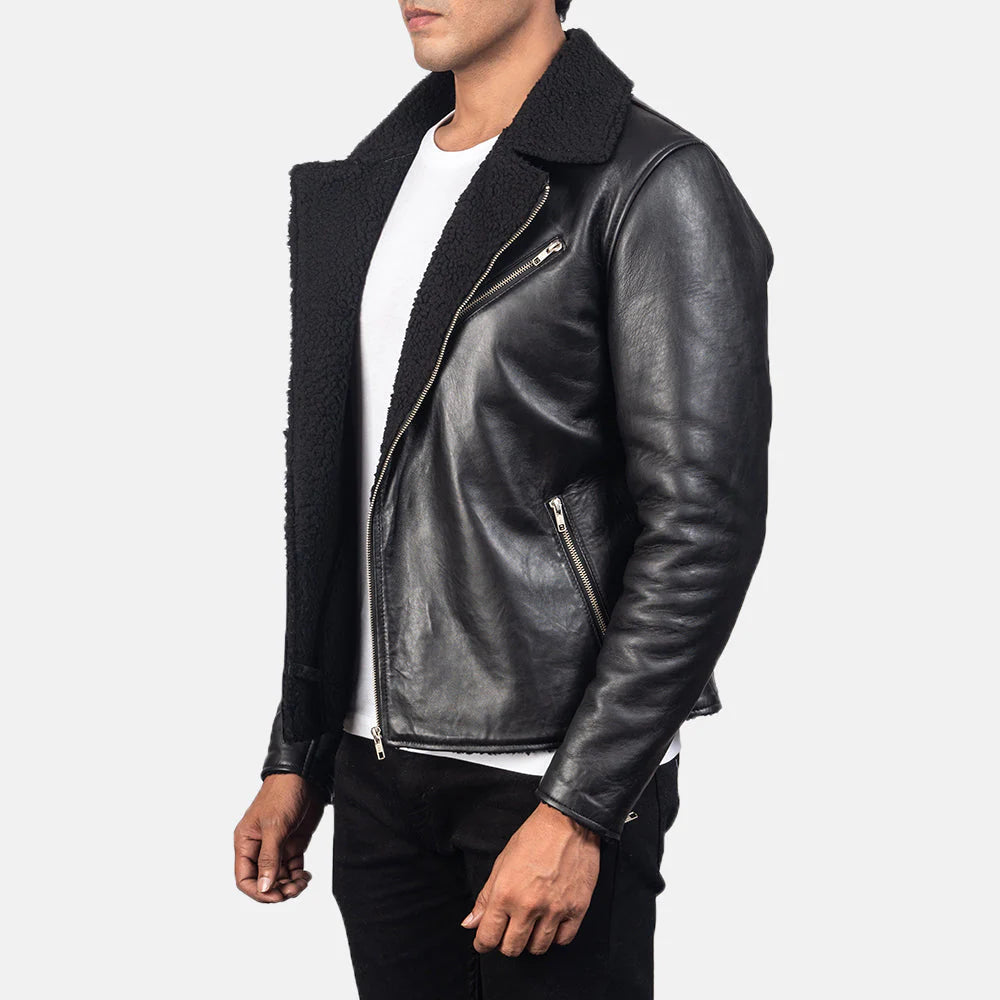 Front view of a man modeling an open black leather jacket featuring a thick, contrasting black sherpa fur collar and lining, zippered pockets, and a white crew neck t-shirt visible underneath.