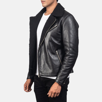 Front view of a man modeling an open black leather jacket featuring a thick, contrasting black sherpa fur collar and lining, zippered pockets, and a white crew neck t-shirt visible underneath.