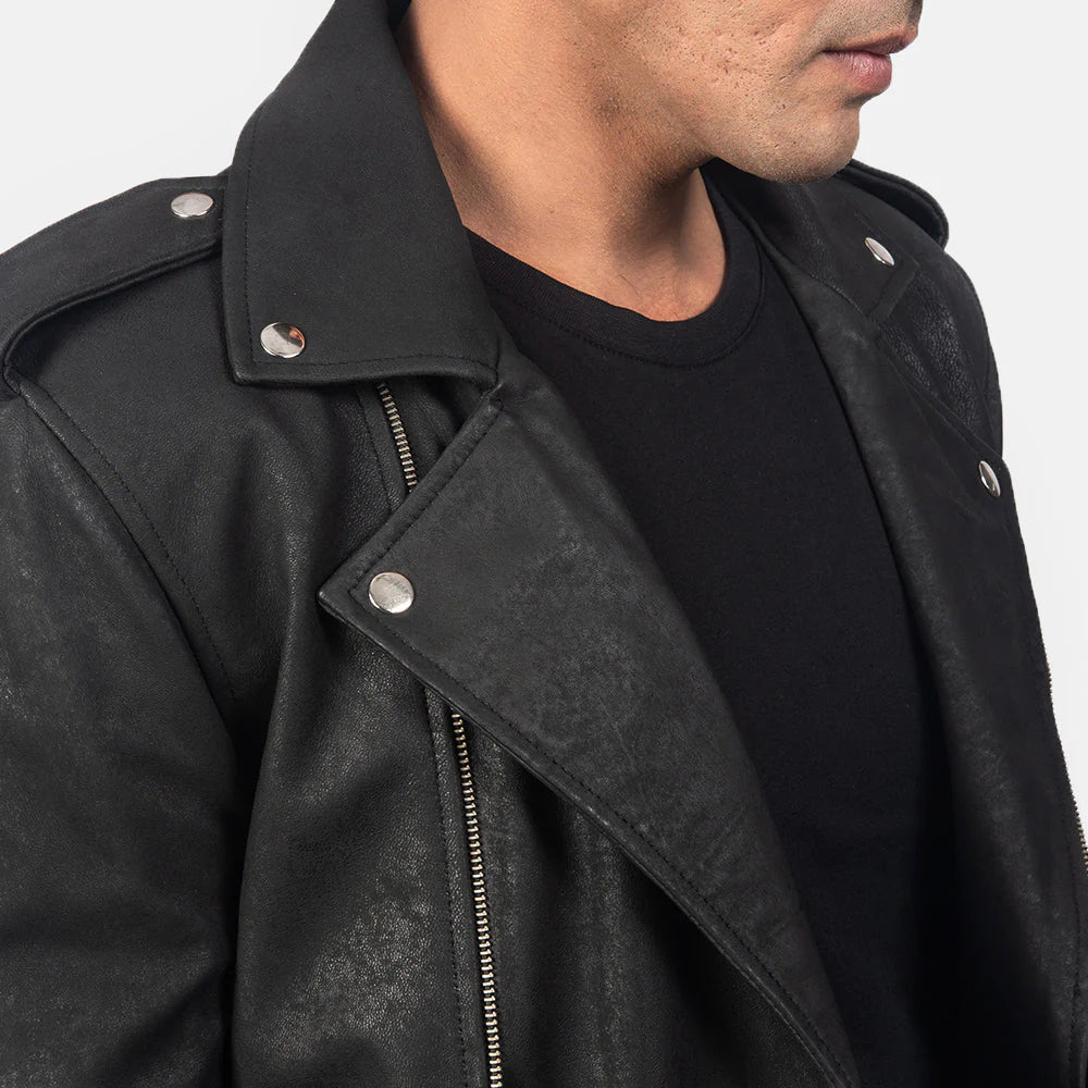 Front view of a man wearing an open black leather jacket with wide lapels, multiple silver zippers, shoulder epaulets, and a waist belt detail.