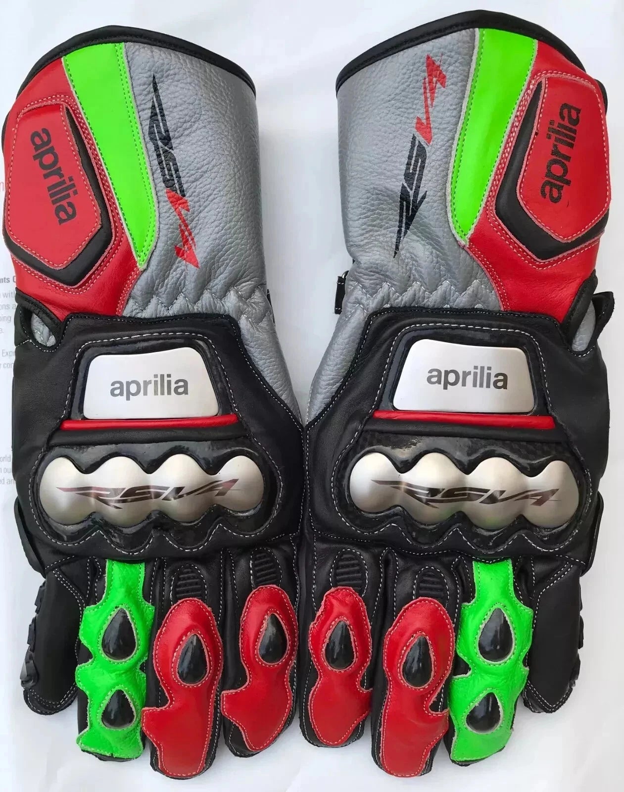 Aprilia RSV4 leather motorcycle racing gloves in neon green, red, and black with metallic knuckle armor.