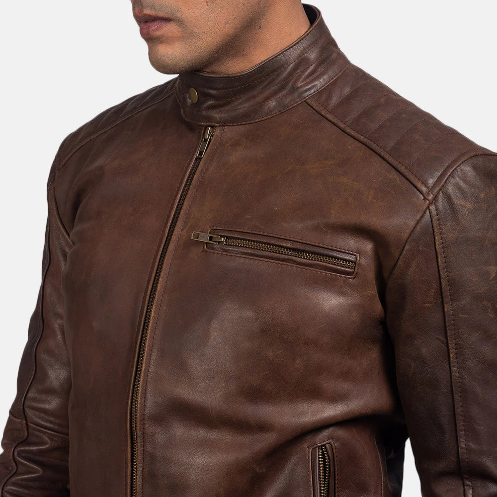 Front view of a man wearing an open dark brown leather jacket, showing the stand collar, zippered chest pocket, and quilted shoulder panels.