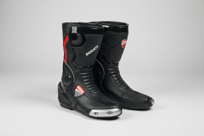 Ducati Corse black leather motorcycle racing boots with metallic toe sliders and red racing accents.