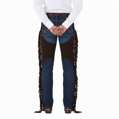 Female rider wearing brown suede protective fringe chaps with adjustable spur straps over blue jeans and an ornate trophy buckle.