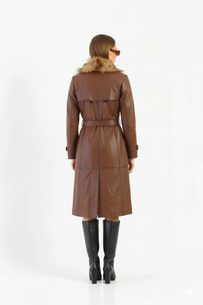 Close-up of the dark rectangular buckle and panel stitching on a premium women's brown leather trench.