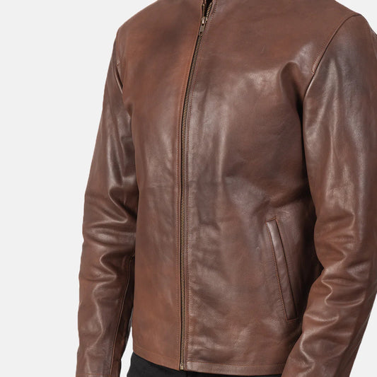Front view of a man modeling an open rich brown leather jacket, showing the stand collar and simple zippered hand pockets.