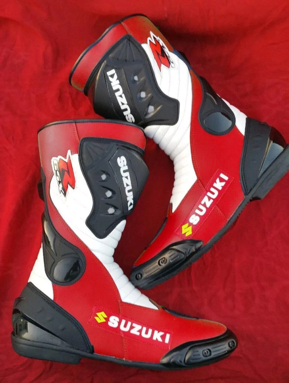 Suzuki GSX tricolor leather motorcycle racing boots in red, white, and black with shin armor."
