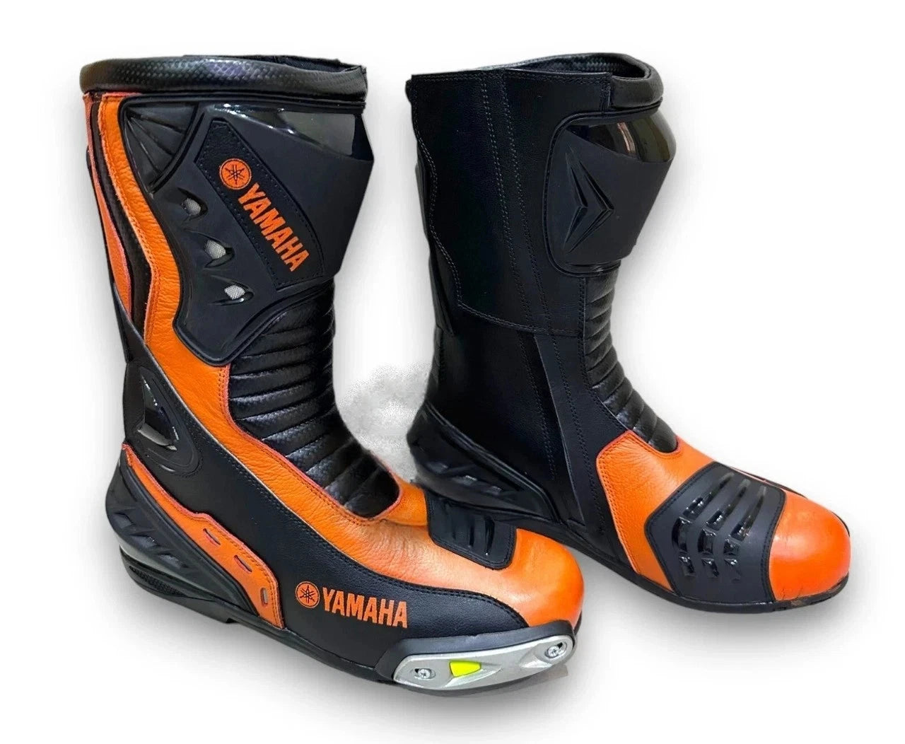Yamaha Racing leather motorcycle boots in orange and black with metallic toe sliders and shin armor.