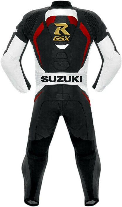 Detailed view of the gold Suzuki GSX logos, white Suzuki chest branding, and professional black knee sliders on a leather track suit.