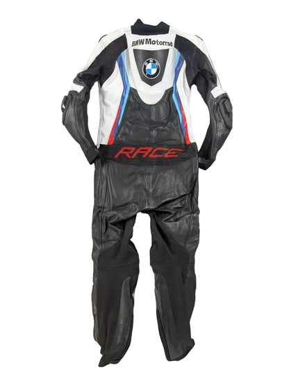 Detailed view of the BMW roundel, perforated leather cooling zones, and professional knee sliders on a racing suit.