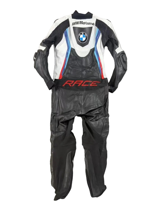Detailed view of the BMW roundel, perforated leather cooling zones, and professional knee sliders on a racing suit.