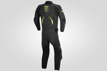 Detailed view of the Monster Energy claw logo, accordion stretch panels, and black knee sliders on a track suit.