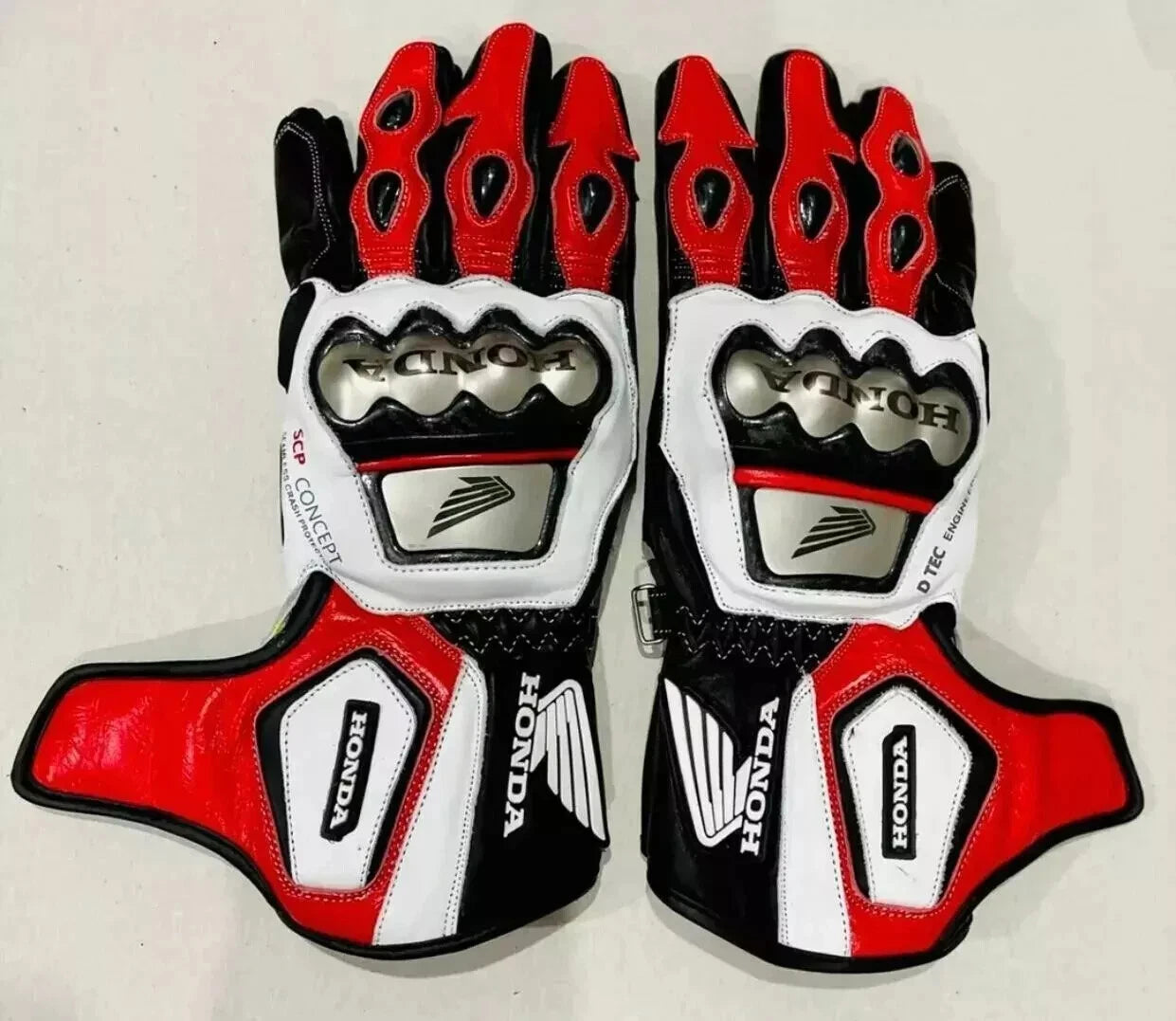 Honda factory racing leather motorcycle gloves in red, white, and black with metallic knuckle armor.