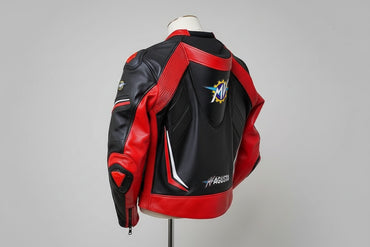 Detailed view of the MV Agusta chest logo, red racing sleeves, and external hard-shell shoulder sliders on a professional racing jacket.