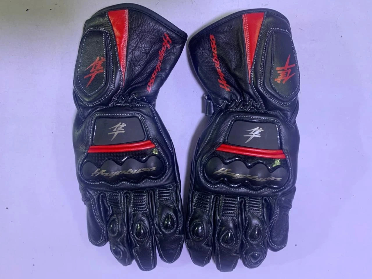 Suzuki Hayabusa leather motorcycle racing gloves in black and red with carbon fiber knuckle armor.