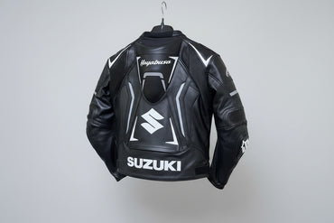 Detailed view of the white Hayabusa Kanji branding, Suzuki forearm logo, and external hard-shell shoulder sliders on a black leather jacket.