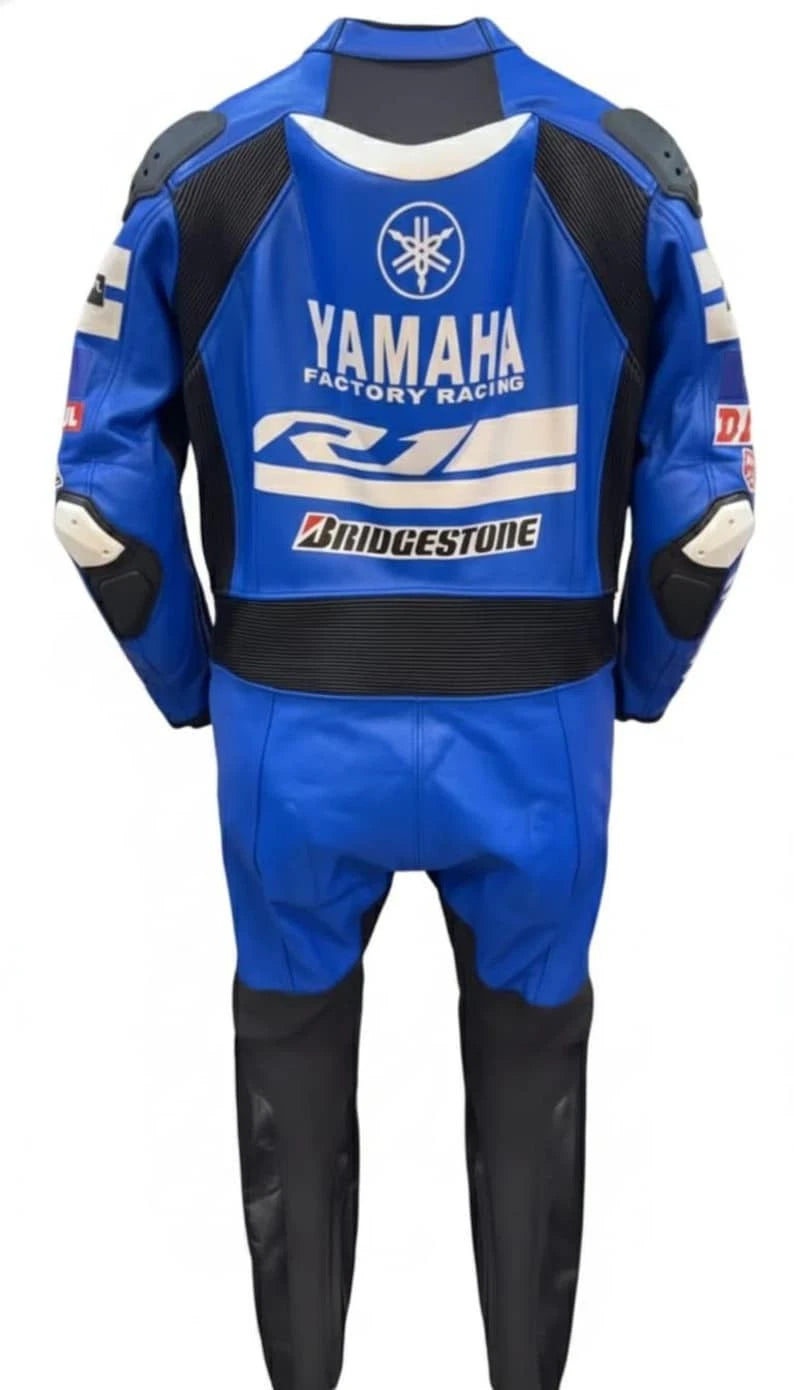 Detailed view of the Monster Energy bridgestone logo, shoulder patches, and red technical leather panels on a one-piece Yamaha racing suit.