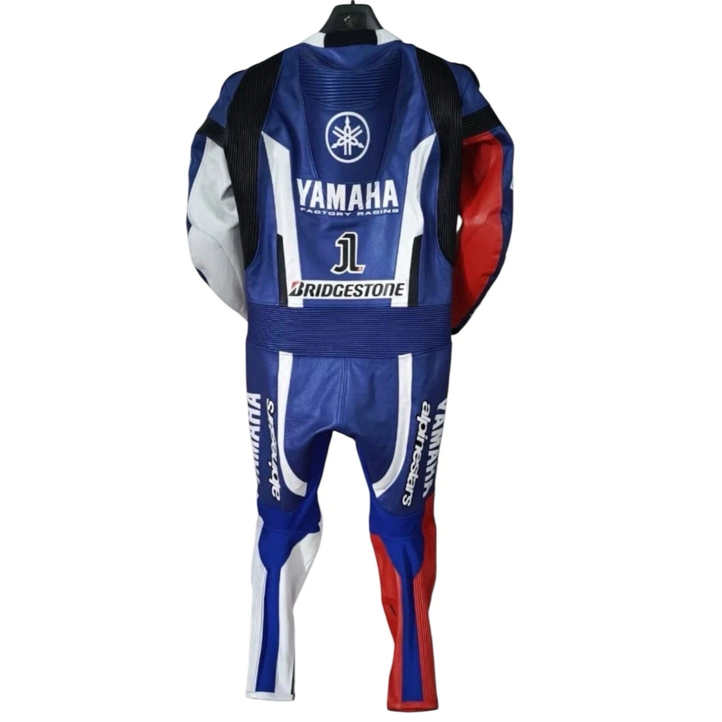 Detailed view of the Yamaha Factory Racing chest branding, Petronas sponsor logos, and white accordion stretch sections on a racing suit.