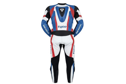 Detailed view of the BMW M roundel, Tyco sponsor patch, and perforated leather panels on a professional racing suit.