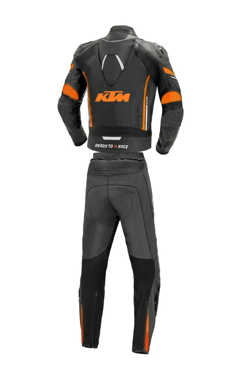 Detailed view of the KTM chest logo, orange aerodynamic strikes, and external knee sliders on a professional racing suit.