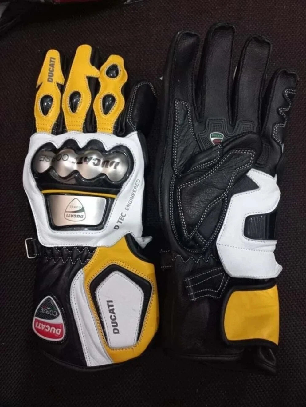 Ducati Corse leather motorcycle racing gloves in yellow, white, and black with metallic knuckle armor.