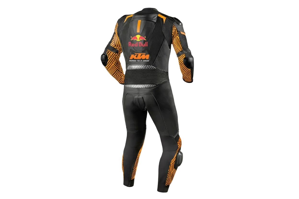 Detailed view of the KTM Ready to Race chest logo, Akrapovič patch, and orange accordion stretch panels on a professional racing suit.