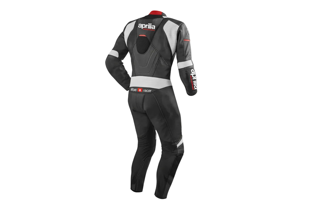Detailed view of the Aprilia Racing chest logo, grey aerodynamic strikes, and red technical accents on a professional racing suit.