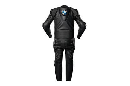Detailed view of the BMW chest logo, perforated leather panels, and black accordion stretch sections on a professional racing suit.